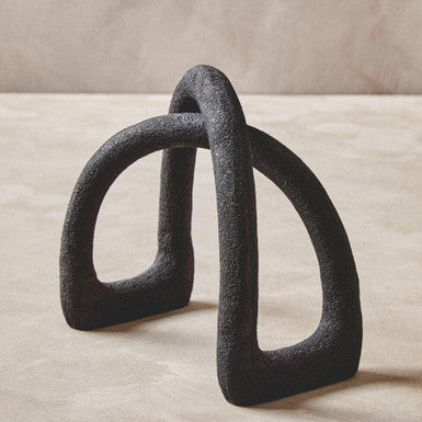 Pair of black ceramic rings on a beige surface