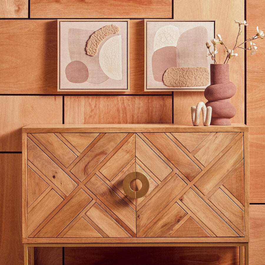 Wooden wall art and cabinet against a wooden paneled wall