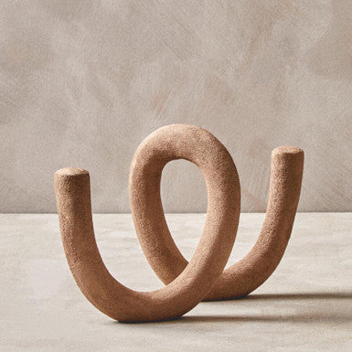 Brown abstract sculpture on a neutral background