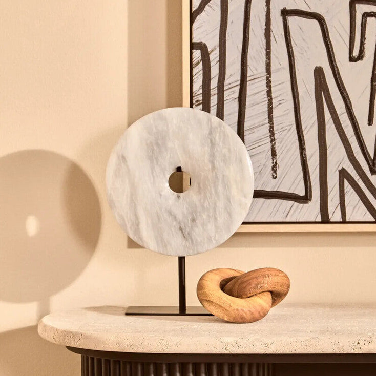 Decorative items on a shelf with abstract art in the background