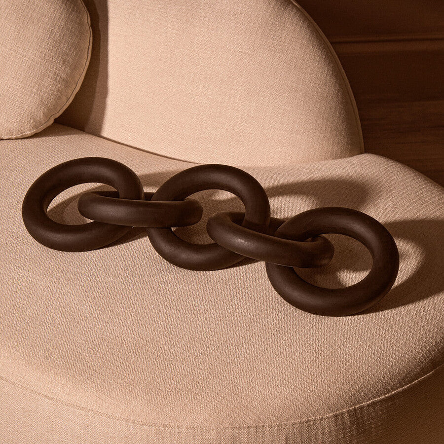 Decorative brown chain on a beige cushion