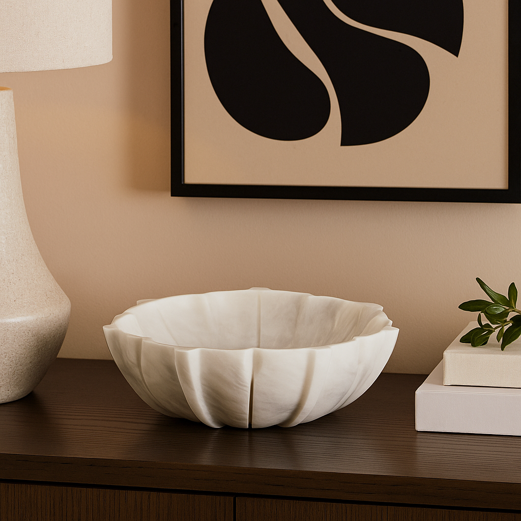 Decorative white bowl on a wooden surface with a lamp and abstract art in the background.