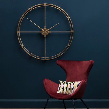 Red chair with a patterned pillow against a dark blue wall with a decorative clock.
