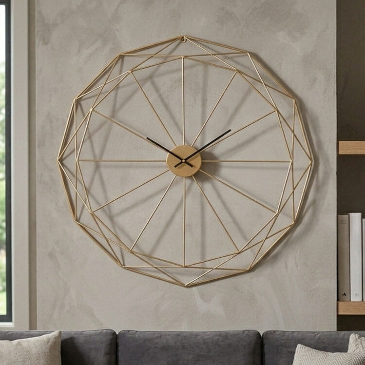 Geometric wall clock on a wall above a gray sofa with a window and bookshelf in the background.