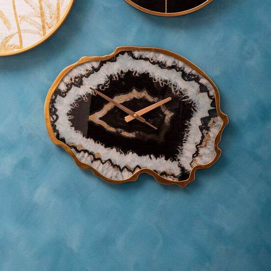 Three decorative coasters with unique designs on a blue textured surface