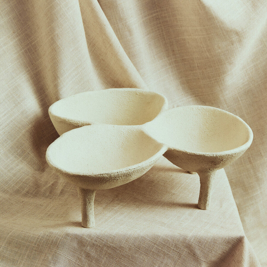 Three ceramic bowls on a beige fabric background