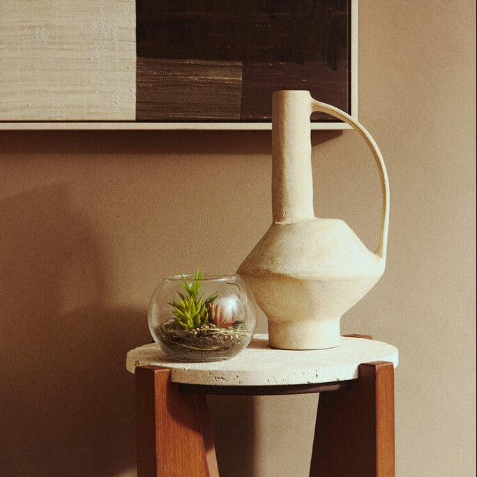 Decorative vase on a side table with a textured wall in the background