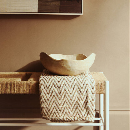 Nestled wooden bowl on a textured surface with abstract art in the background