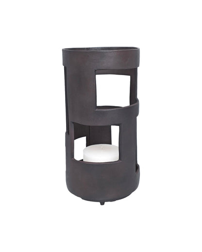 Black cylindrical lantern with a white candle inside on a white background