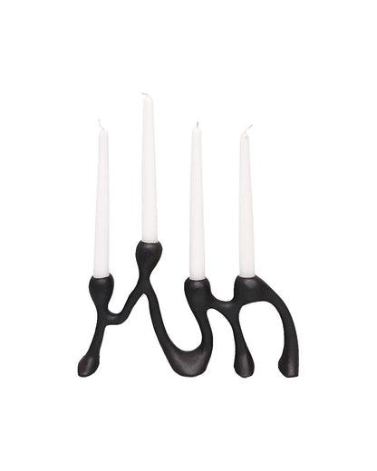 Black candle holder with four white candles on a white background