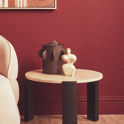 Modern armchair with a decorative pillow in a room with a red wall and abstract art.