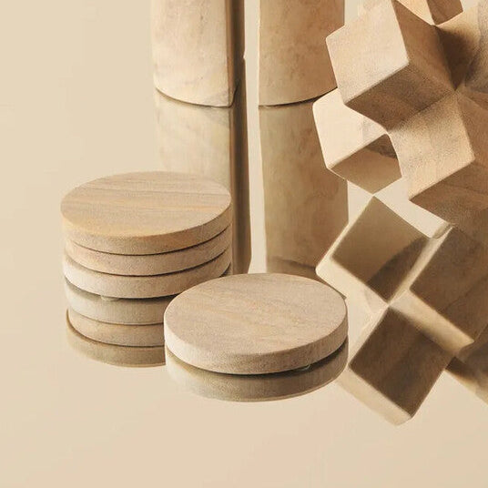 Wooden geometric shapes on a reflective surface with a beige background