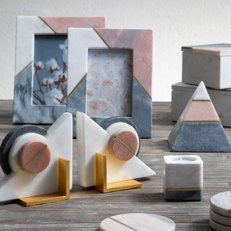 Geometric photo frames and decorative items on a wooden surface with a neutral background