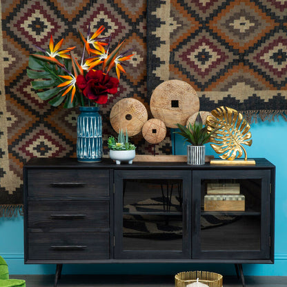 Living room with a black sideboard, decorative items, and a colorful rug.