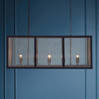 Rectangular pendant light with mesh cover against a blue wall