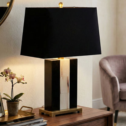 Black table lamp on a wooden surface with a blurred background