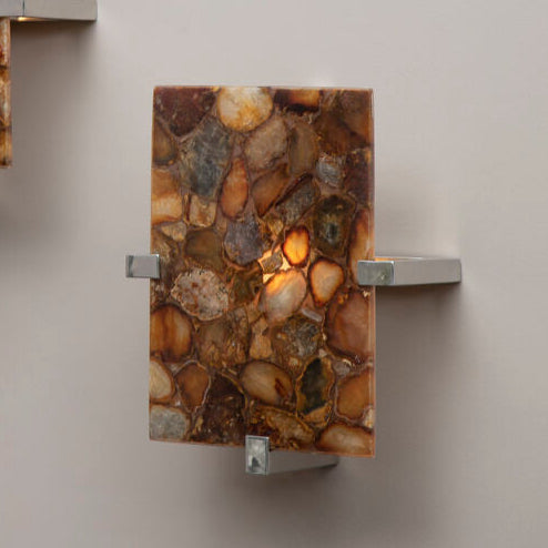 Two wall sconces with stone-like design on a plain wall.