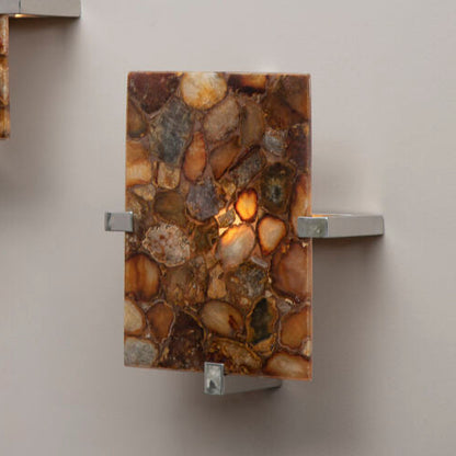 Two wall sconces with stone-like design on a plain wall.