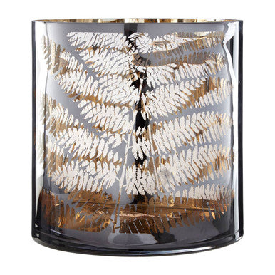 Decorative glass candle holder with leaf pattern on a white background
