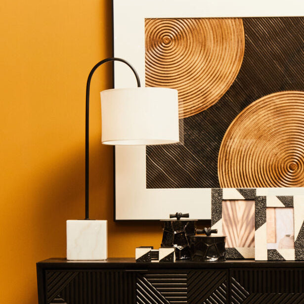 Console table with decorative items against a yellow wall