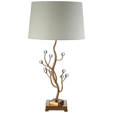 Decorative table lamp with a gold branch design and white shade on a white background
