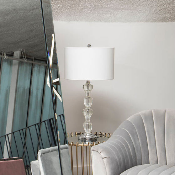 Tall floor mirror with geometric design in a room with a chair and lamp.