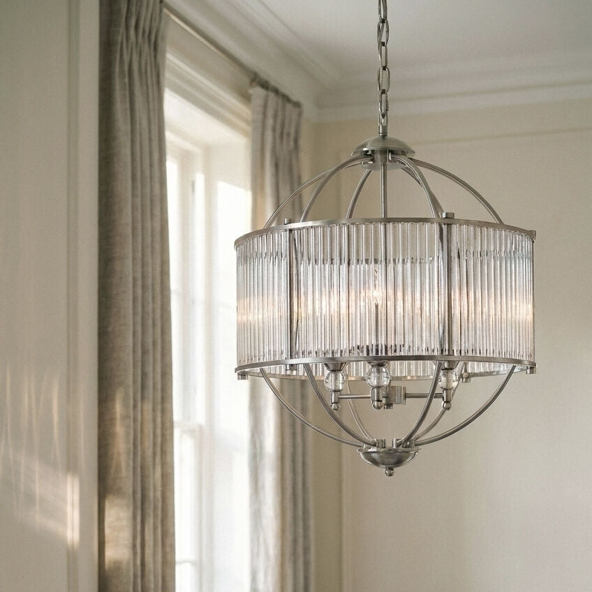 Chandelier hanging in a room with curtains and light filtering through