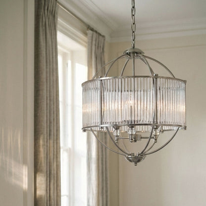 Chandelier hanging in a room with curtains and light filtering through