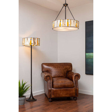 Brown leather armchair in a room with a pendant light and floor lamp.
