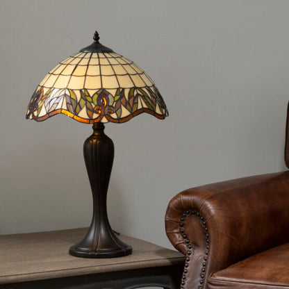 Brown leather armchair next to a table with a decorative lamp against a gray wall.