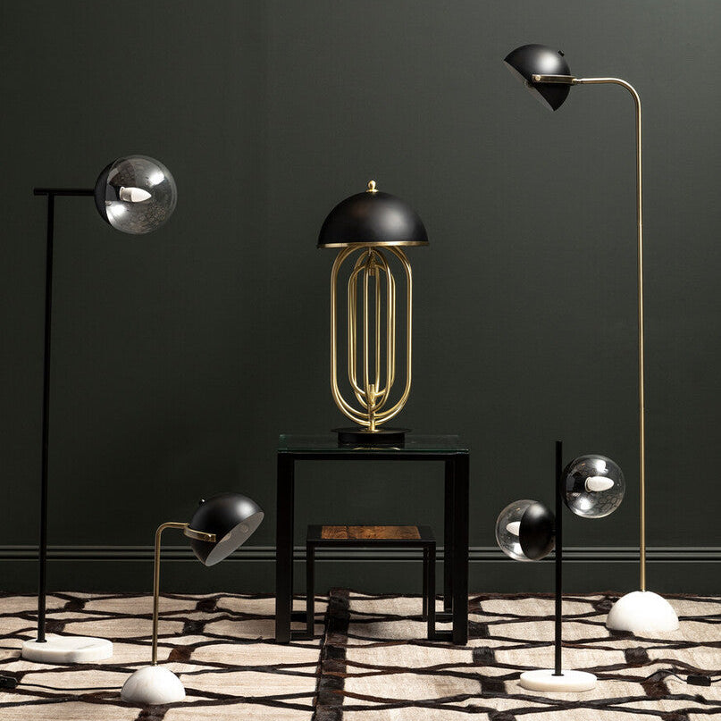Modern floor lamps with gold and black designs on a dark wall.
