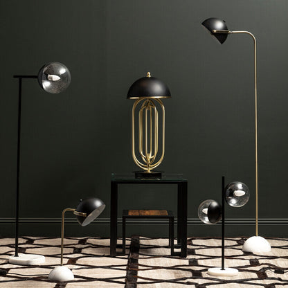 Modern floor lamps with gold and black designs on a dark wall.