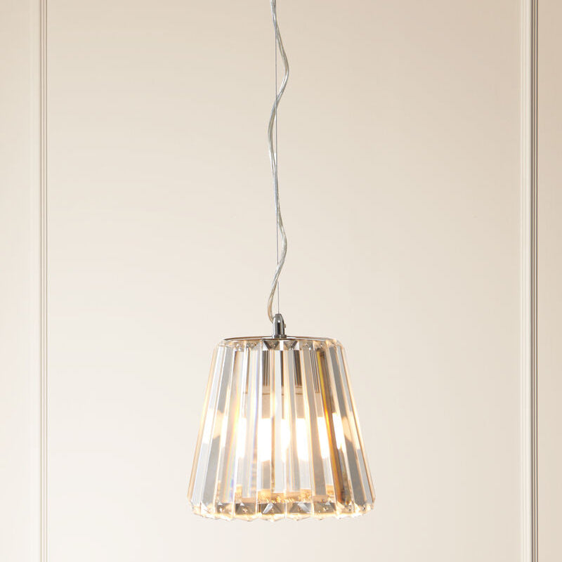 Modern pendant light with transparent shade against a neutral wall