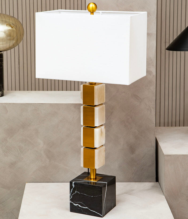 Modern table lamp with gold and black base on a white surface