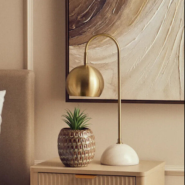 Beige nightstand with decorative items next to a bed in a bedroom setting