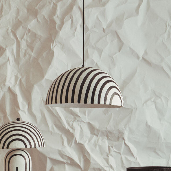 Decorative vases and a lamp with black and white patterns on a textured white background
