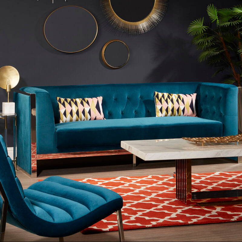 Modern living room with blue sofa, decorative mirrors, and a chandelier.