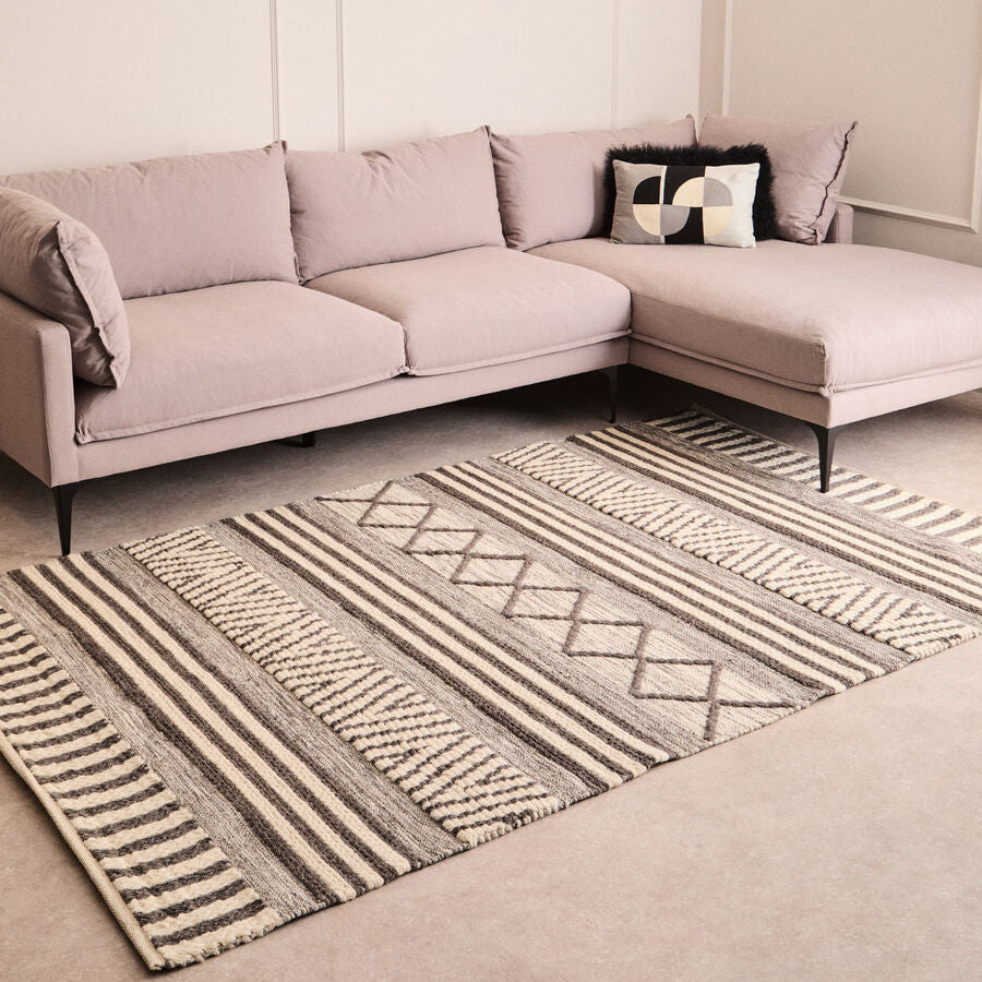 Sectional sofa with a patterned rug in a living room setting