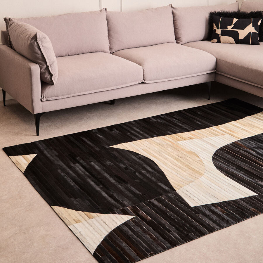 Modern living room with a sectional sofa and a geometric patterned rug.