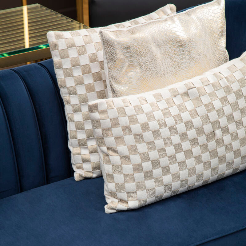 Three decorative pillows on a blue sofa with a checkered pattern.