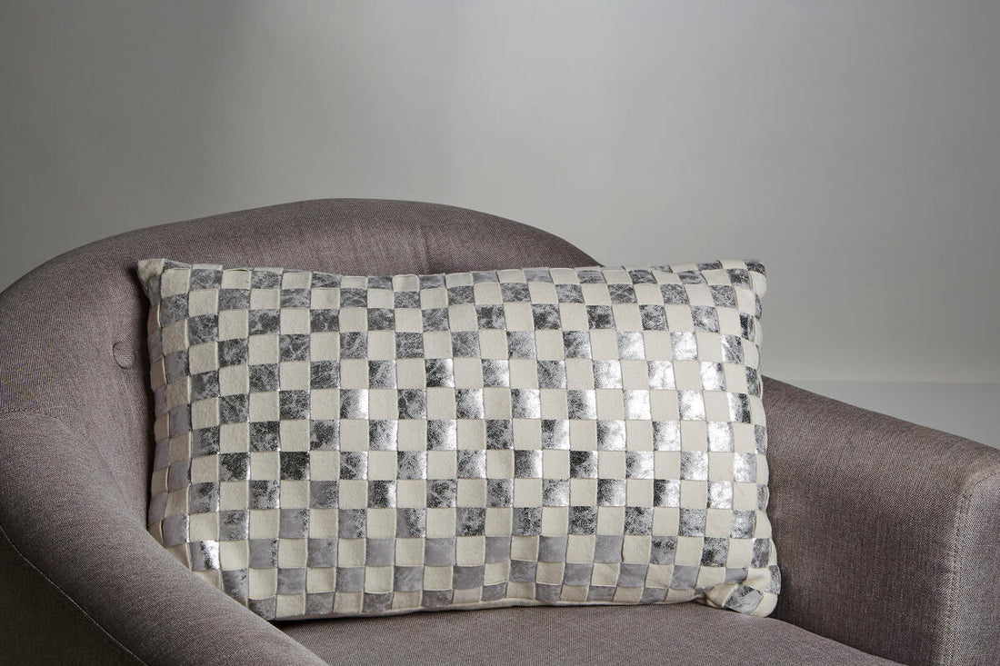 Checkered pillow on a gray sofa against a plain background