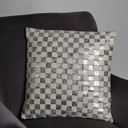 Decorative pillow with a checkered pattern on a dark sofa against a plain background