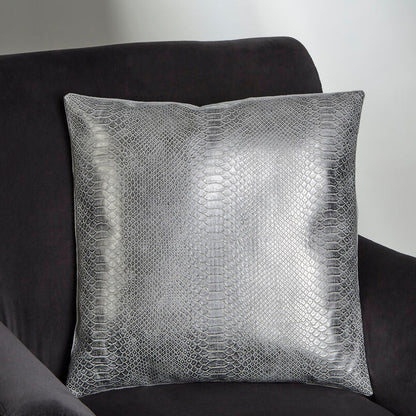 Silver textured pillow on a dark gray sofa against a plain background