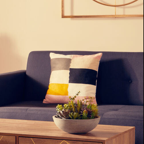 Modern living room with a blue sofa, wooden coffee table, and decorative items.