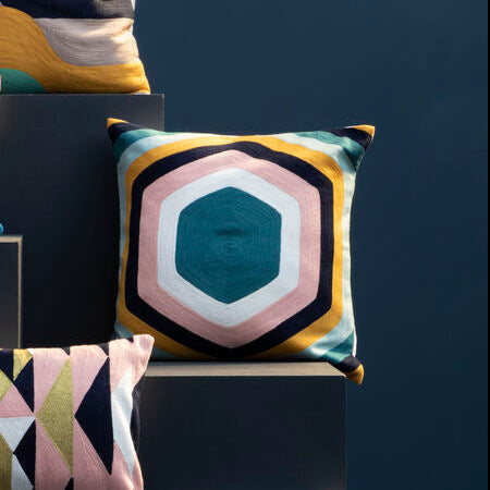 Colorful geometric-patterned pillows on a dark background