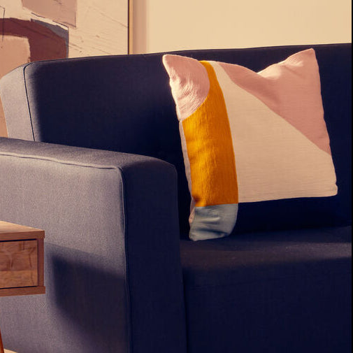 Navy blue sofa with colorful pillows in a living room setting.