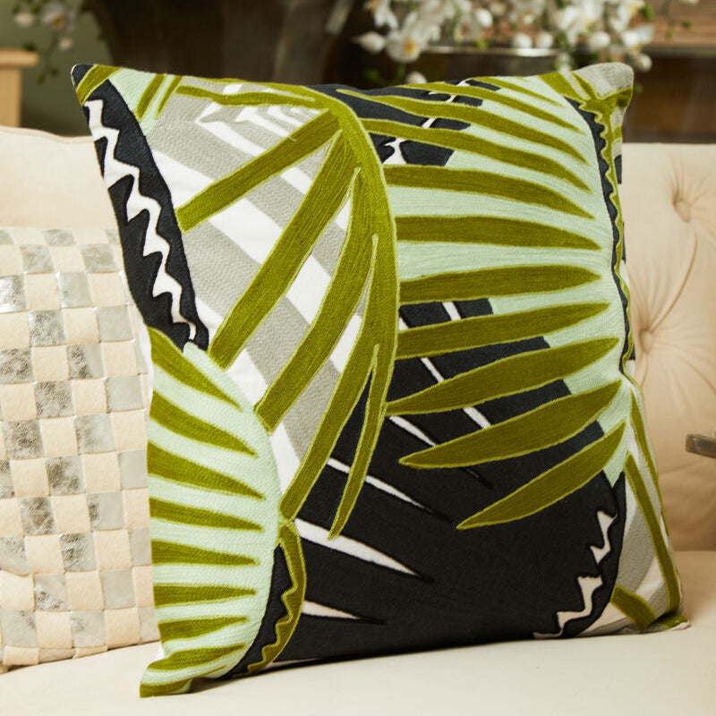 Decorative pillow with green leaf pattern on a couch
