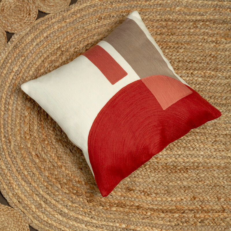 Decorative pillow with red and beige pattern on a textured surface