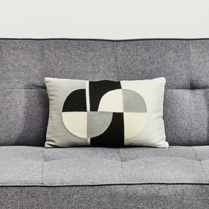 Gray sofa with a geometric-patterned pillow on a light background