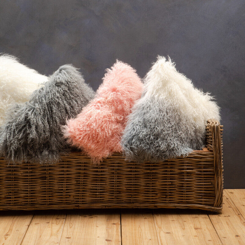 Wicker basket with fluffy textured pillows against a dark background